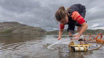 Václava Hazuková, cellting water samples from an Arctic lake.  

Václava Hazuková samlar in vattenprover från en arktiskt sjö.