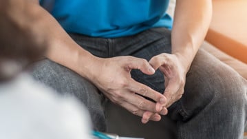 Male patient having consultation with doctor or psychiatrist who working on diagnostic examination on men's health disease or mental illness in medical clinic or hospital mental health service center.