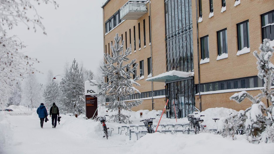 Ett större tegel hus står på vänster sida. Det är vinter.