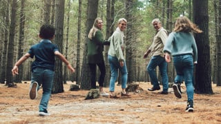 Forest, big family and adventure with children, parents and grandparents walking in nature for outdoor hiking, fun and trees on wellness vacation. Running kids, travel and happy man and women in woods
