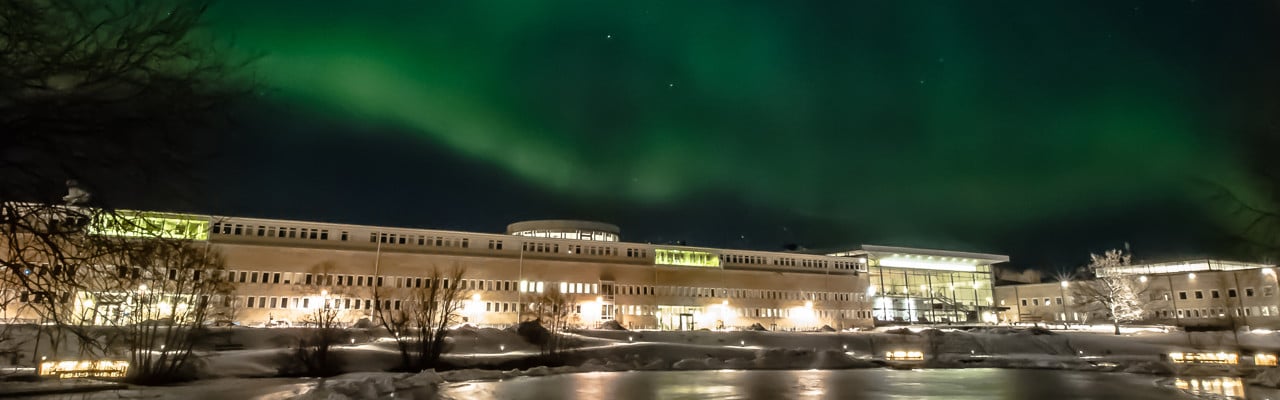 Norrsken över samhällsvetarhuset och universitetsdammen vintern 2015. Bilden är tagen av Maylis Saigot och upplåten för UmU att användas i enlighet med UmU:s Copyright Transfer Agreement.