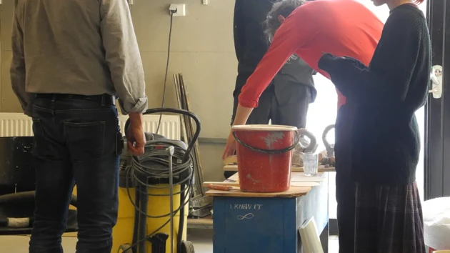 Four people in the foundry are discussing the moulding process.