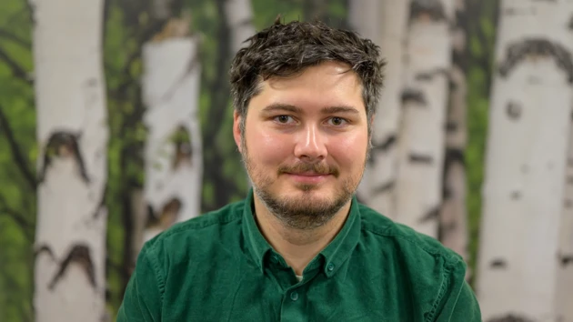 En man  framför en björk tapetbakgrund