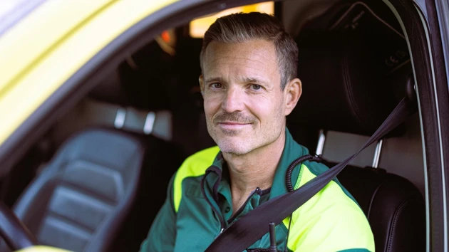 En manlig ambulansförare sitter i en ambulansbil.