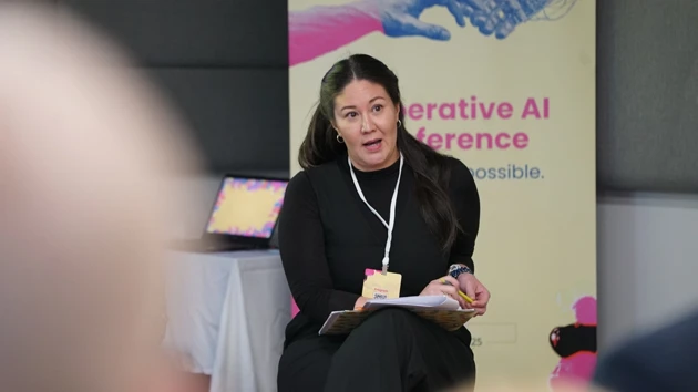 A woman sitting on a chair in front of a microphone.
