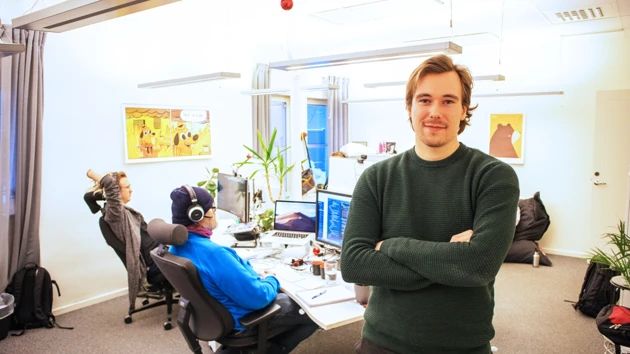 Bild på Peter Bjuhr, stående i kontorslandskapet på Codemill, medarbetare vid skrivbord i bakgrunden