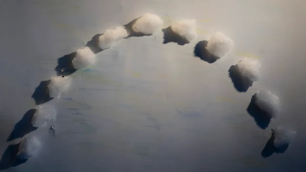 Snöklumpar i halvcirkel på vitt papper