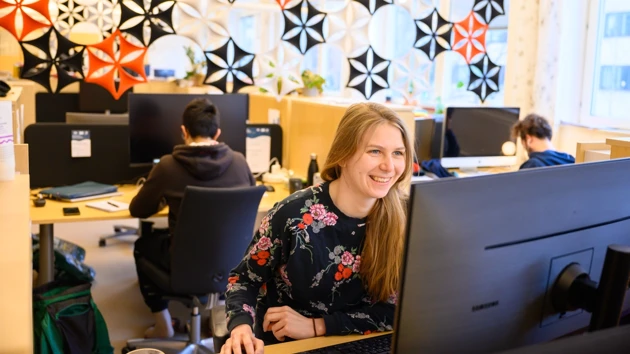 Kvinna som sitter i framför datorn i ett digitalt möte.