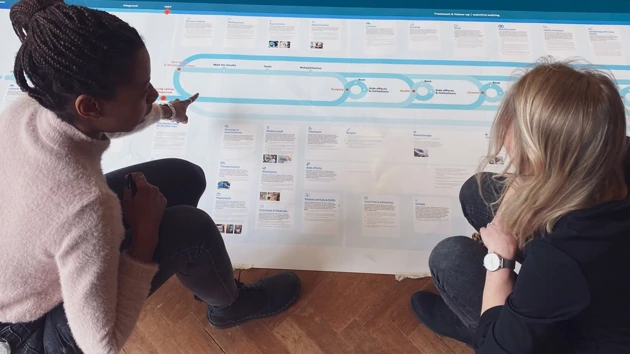 Sharon Williams i arbete, leder samarbetsinriktade designsessioner för att skapa digitala verktyg som stärker vårdpersonal och förbättrar patientvården.