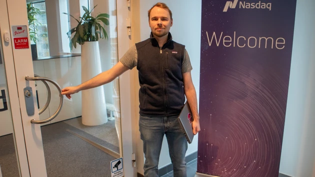 Bild på William Fransson vid entrén till Nasdaqs kontor i Umeå