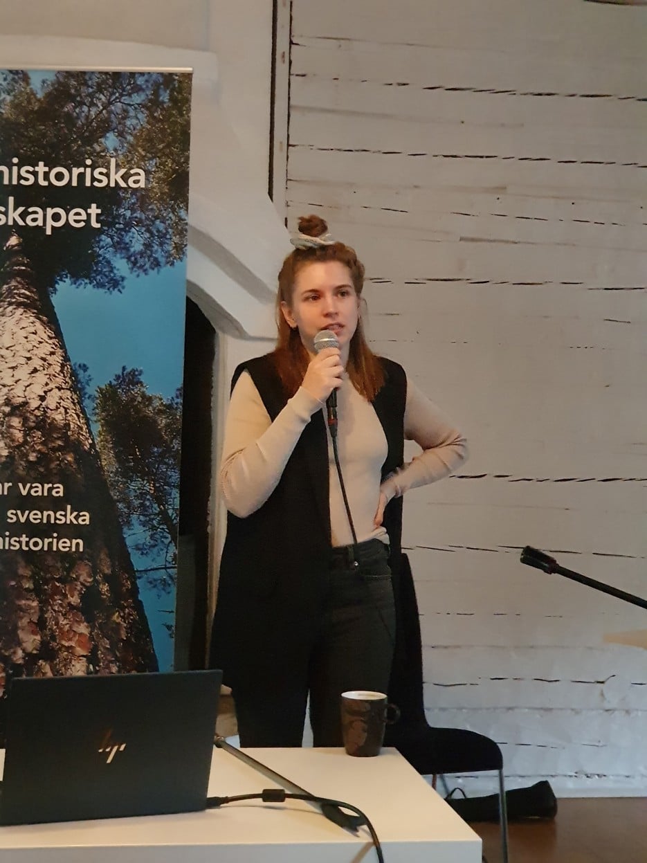 Irma Olofsson står och talar med en mikrofon i handen