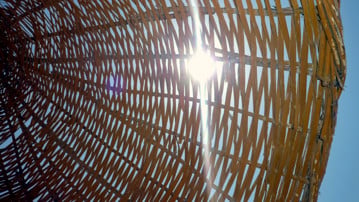 Solen skiner genom ett parasoll i rotting.