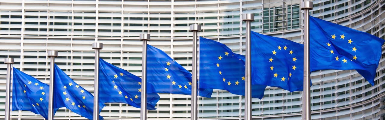 Eu-flaggor i rad framför EU-kommissionens fasad.