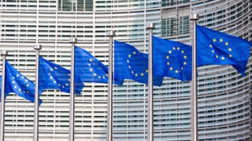 Eu-flaggor i rad framför EU-kommissionens fasad.