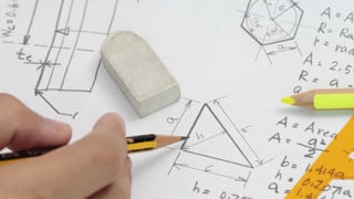 Beräkning av yta för triangel. Papper, hand, penna och sudd.