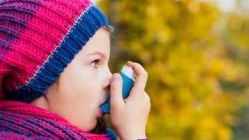 Astmasjukt barn inhalerar astmamedicin.