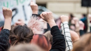 Knutna nävar vid demonstration för jämställdhet.