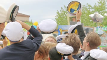 Nyblivna studenter med studentmössor firar sin examen.