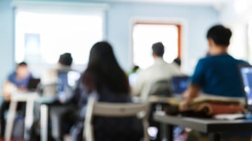 Utsuddade personer i en lektionssal som är med på en föreläsning eller seminarium.