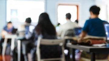 Utsuddade personer i en lektionssal som är med på en föreläsning eller seminarium.