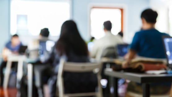 Utsuddade personer i en lektionssal som är med på en föreläsning eller seminarium.