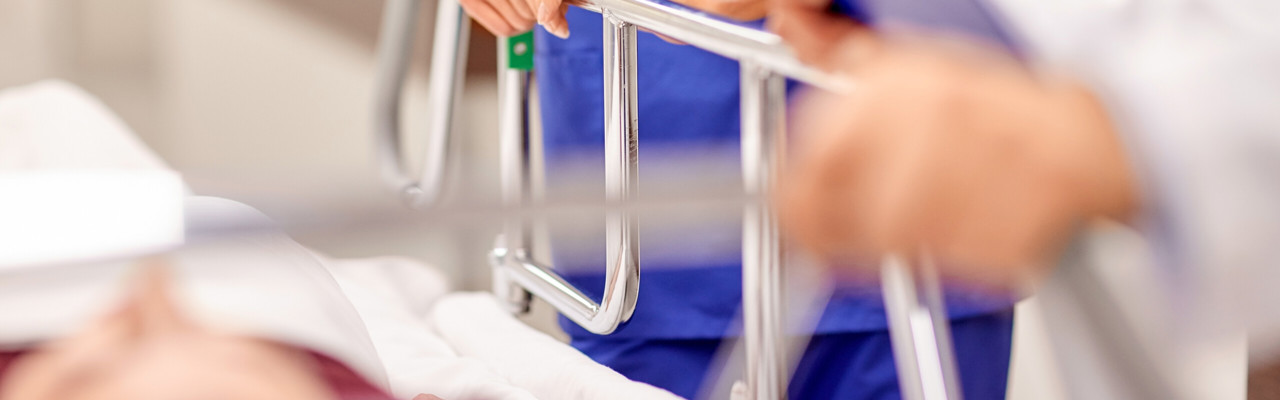 Detalj från en akutvårdsavdelning. Vårdpersonal med en patient på bår.
