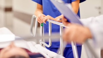 Detalj från en akutvårdsavdelning. Vårdpersonal med en patient på bår.