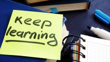 Post-it-lapp med texten keep learning. För att illustrera livslångt lärande.