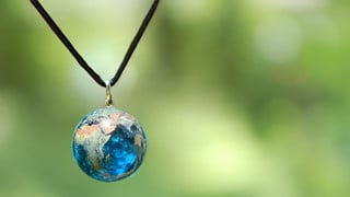 Halsband med hänge i form av ett jordklot i glas.