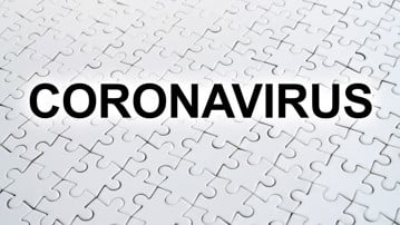 Ordet Coronavirus skrivet ovanpå ett vitt pussel.
