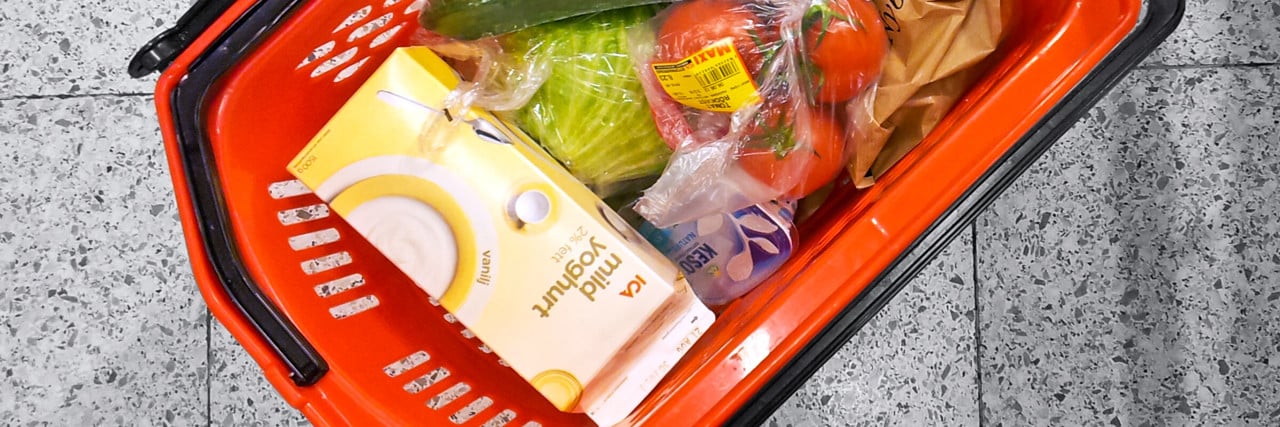 Varukorg med matvaror står på butiksgolv.