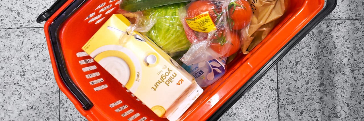 Varukorg med matvaror står på butiksgolv.