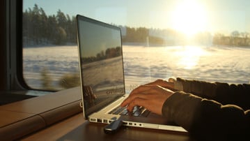 Bild på person med laptop på tåg