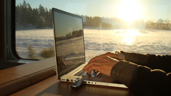 Bild på person med laptop på tåg
