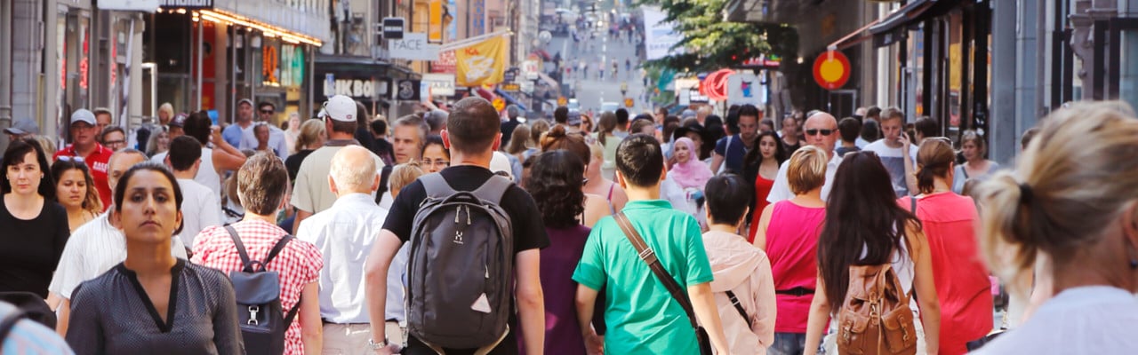 Sommardag på gågatan Drottninggatan mellan Mäster Samuelsgatan och Kungsgatan i Stockholm, Sverige, med folk i rörelse.