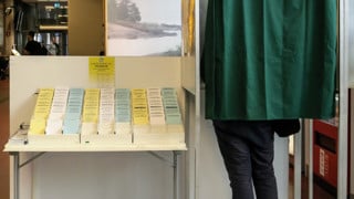 Person som avlägger förtidsröst i båset i en vallokal.