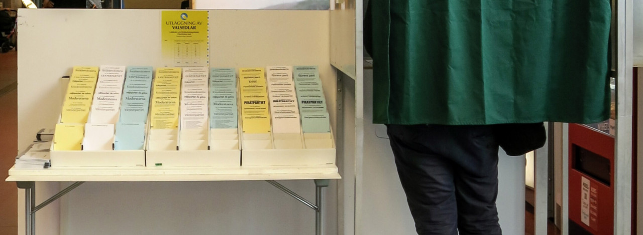 Person som avlägger förtidsröst i båset i en vallokal.