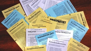 Valsedlar från olika partier utbredda på ett bord.