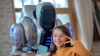 Bild på en vänligt sinnad robot och en flicka som utstrålar glädje