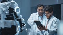 Bilden visar forskare som står framför en robot.