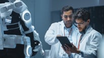 Bilden visar forskare som står framför en robot.