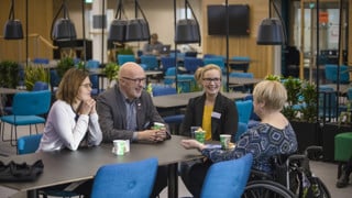 Deltagare i AIMday 2018 samtalar vid ett bord.