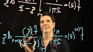 Bild på Berit Bengtson, programansvarig för kandidatprogrammet i Matematik vid Umeå universitet som står framför en lightboard och skriver matematiska formler.