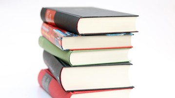 Bild på fem böcker i en hög som illustrerar kurslitteratur.