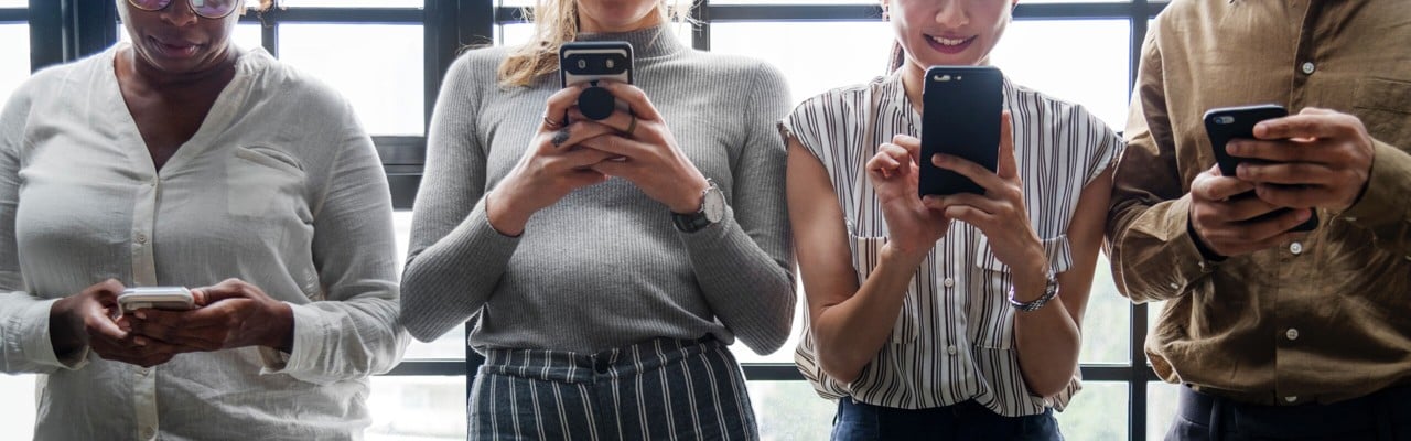 Fyra personer tittar på sina mobiltelefoner