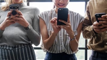Fyra personer tittar på sina mobiltelefoner