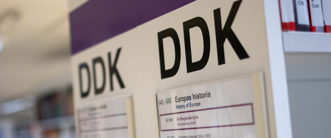 DDK-skylt på en av bibliotekets hyllgavlar
