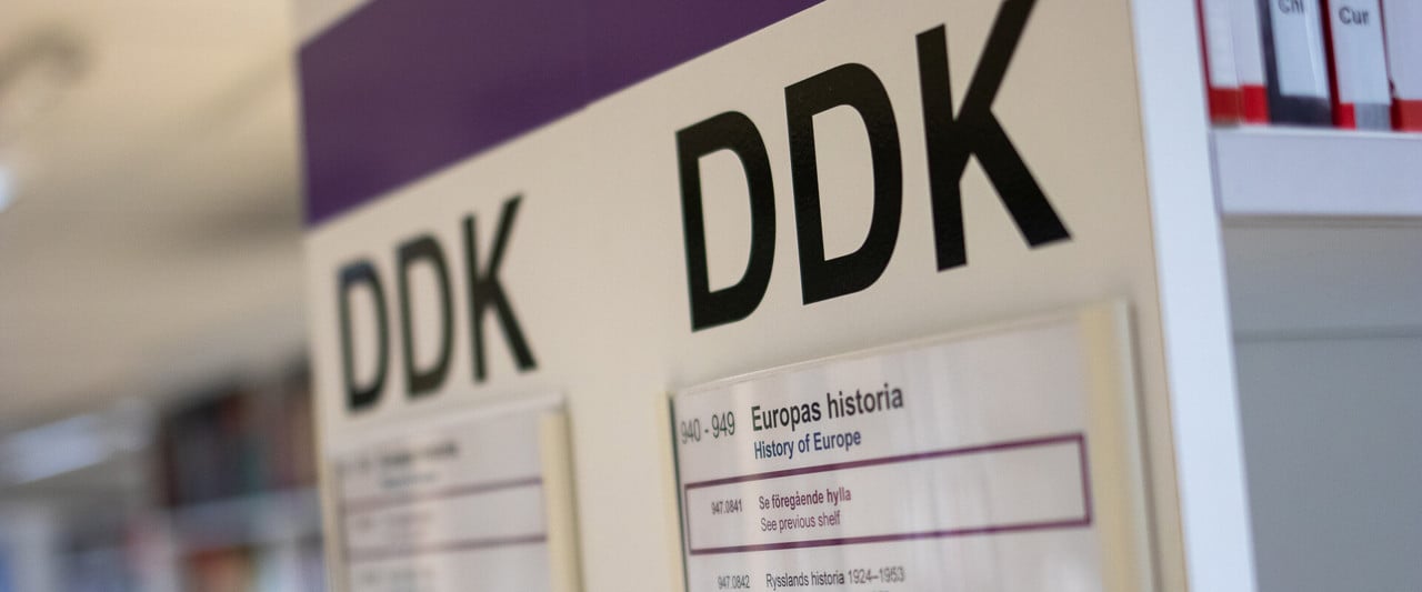 DDK-skylt på en av bibliotekets hyllgavlar