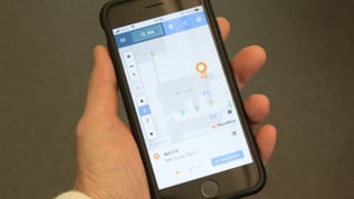 Bild på hand som håller mobiltelefon som visar den digitala kartan över campusområdet.