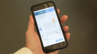 Bild på hand som håller mobiltelefon som visar den digitala kartan över campusområdet.